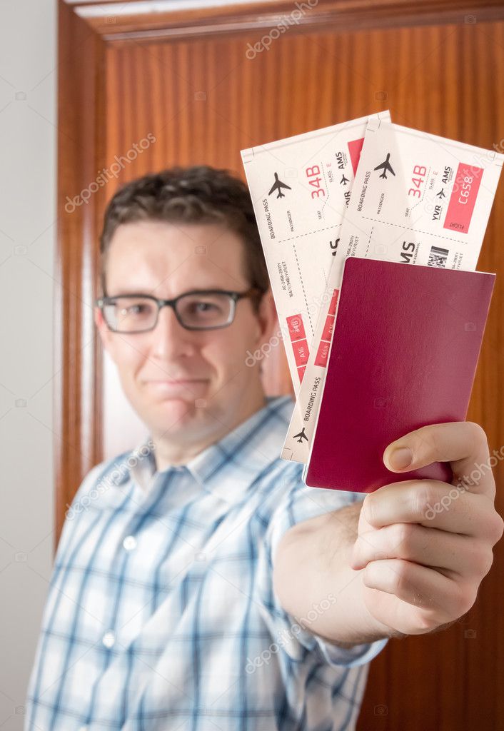 Happy man showing boarding pass and passport