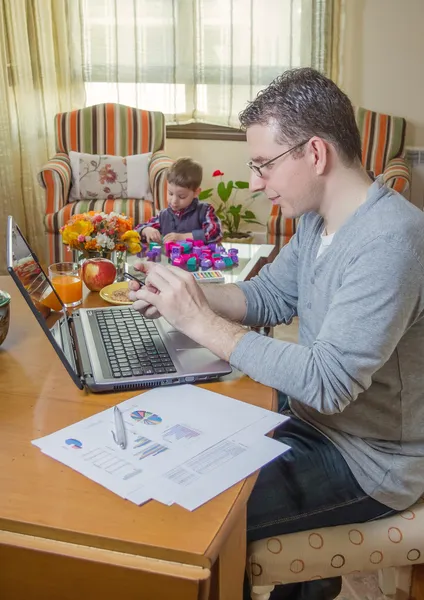 Father working in home office and son playing — Stock Photo, Image