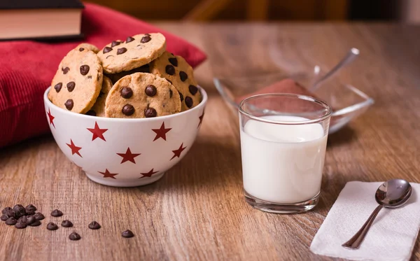 Biscoitos de chocolate e leite no fundo de madeira — Fotografia de Stock