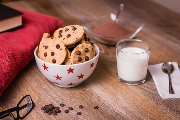Czekoladowe ciasteczka i mleko na tle drewna — Zdjęcie stockowe
