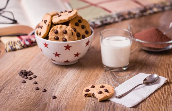 Печенье с шоколадной крошкой и молоко на дереве — стоковое фото