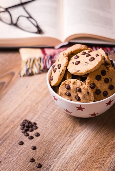 Galletas de chispas de chocolate y libro sobre fondo de madera —  Fotos de Stock