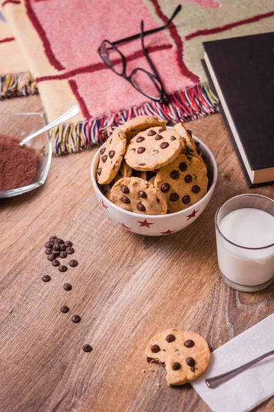 Biscoitos de chocolate e leite no fundo de madeira — Fotografia de Stock