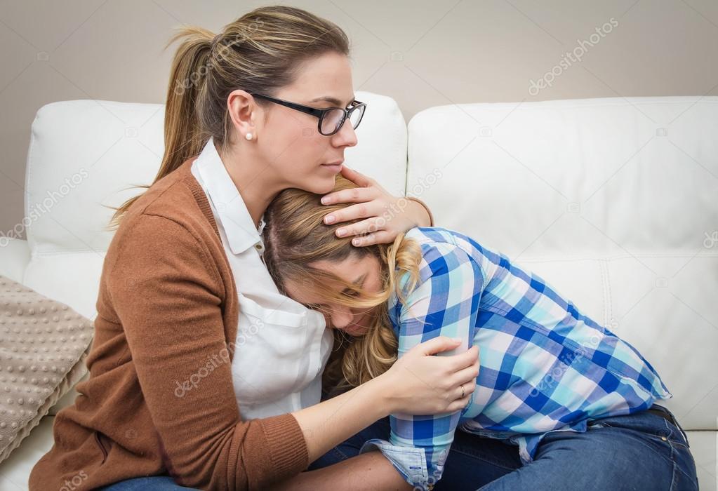 Mother embracing and soothes depressed daughter