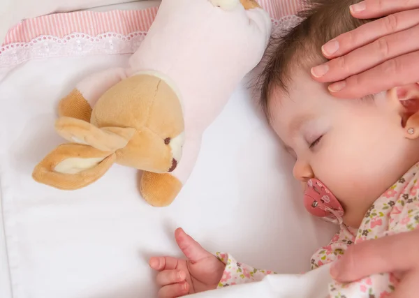 Hände der Mutter streicheln ihr schlafendes Baby — Stockfoto