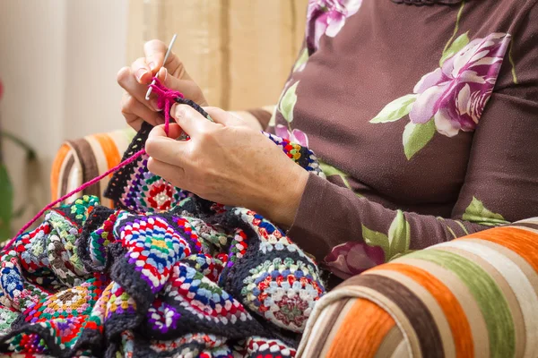 Mani di donna che lavora a maglia una trapunta di lana vintage — Foto Stock