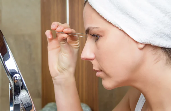 Retrato de niña arrancando cejas con pinzas — Foto de Stock