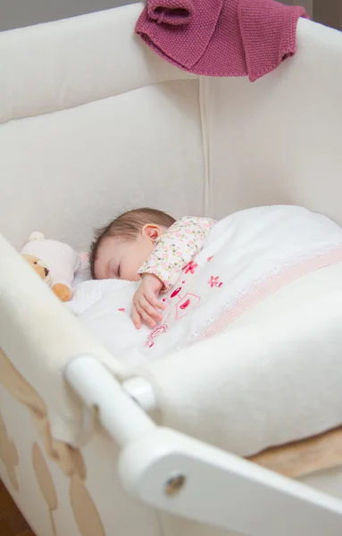 Baby girl sleeping in a cot with pacifier and toy — Stock Photo, Image