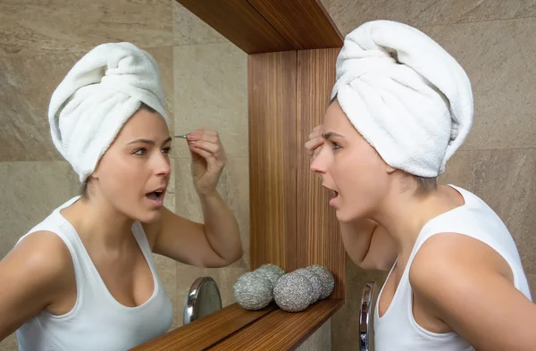 Portrait of girl plucking eyebrows with tweezers — Stock Photo, Image