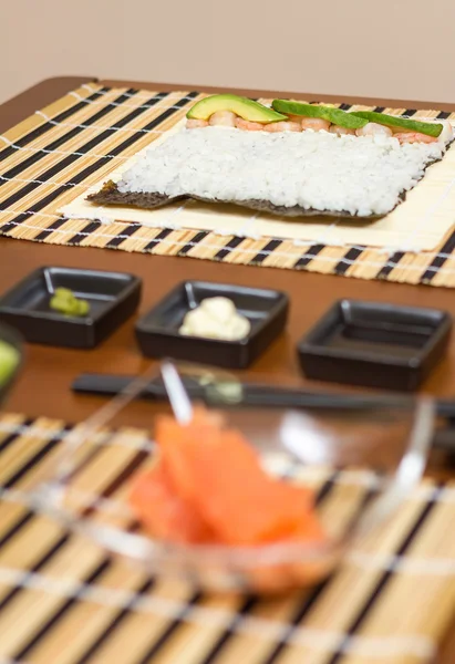 Japanese sushi with rice ready to roll on a table