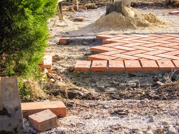 Pedras de pavimentação de tijolo laranja no processo de construção — Fotografia de Stock