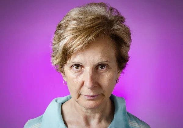 Retrato de mulher séria real sobre fundo roxo — Fotografia de Stock