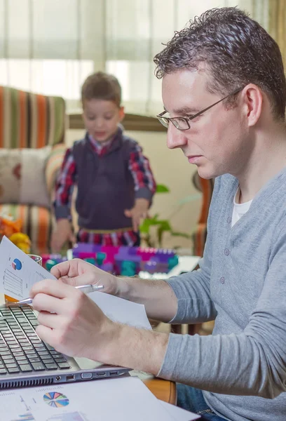 Far arbetar i hemmakontor och son spelar — Stockfoto