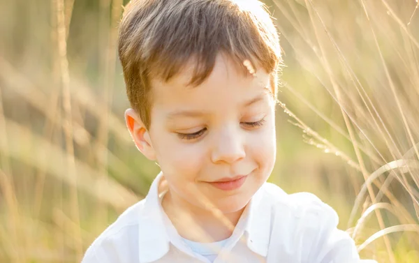 Kid in veld spelen met pieken bij zonsondergang zomer — Stockfoto