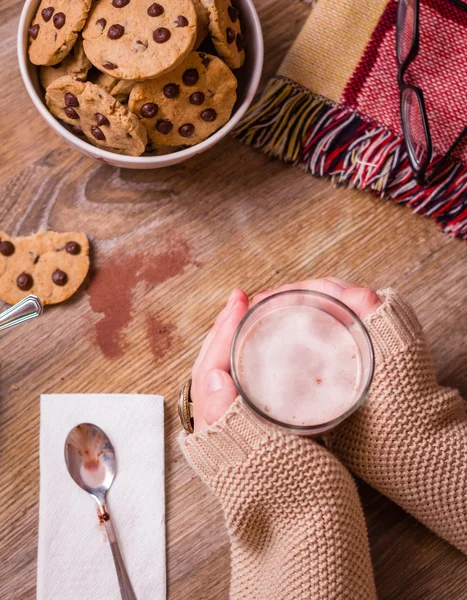 Mani femminili con bevanda calda e biscotti al cioccolato — Foto Stock