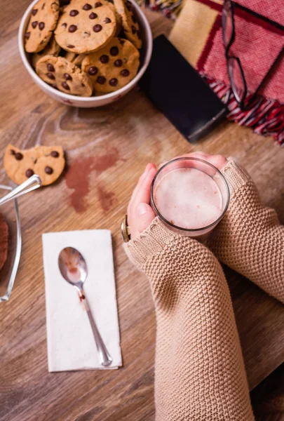 Female hands with hot drink and chocolate cookies — Stock Photo, Image
