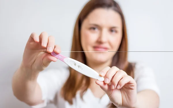 Glückliche Frau zeigt ihren positiven Schwangerschaftstest — Stockfoto