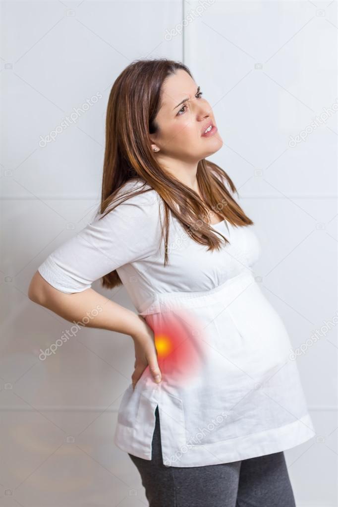 Pregnant woman with strong pain massaging her back