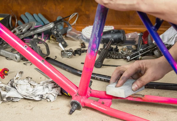 Hände eines echten Fahrradmechanikers schleifen Rahmenfahrrad — Stockfoto