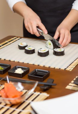 Closeup kadın Şef kesme Japon suşi roll