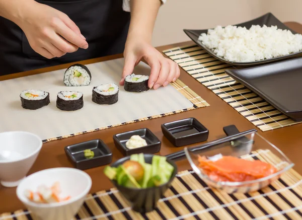 Primer plano de la mujer chef poniendo rollo de sushi japonés —  Fotos de Stock