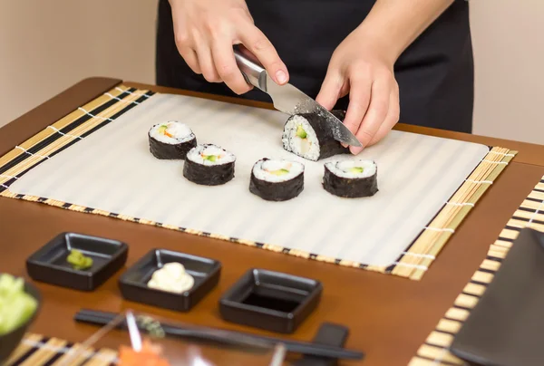 特写的女厨师切割日本寿司卷 — 图库照片