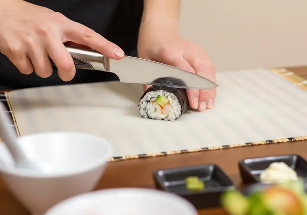 Gros plan de femme chef coupe japonais sushi rouleau — Photo