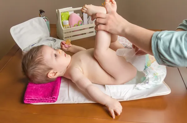 Madre cambiando pañal de adorable bebé — Foto de Stock