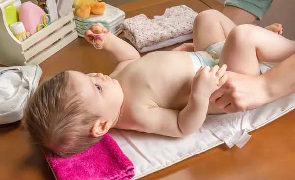 Madre cambiando pañal de adorable bebé — Foto de Stock