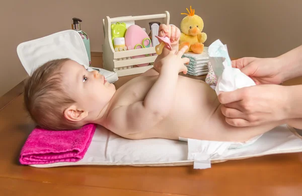 Madre cambiando pañal de adorable bebé — Foto de Stock
