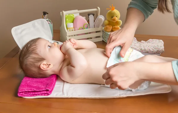 Mutter wechselt Windel von entzückendem Baby Stockfoto