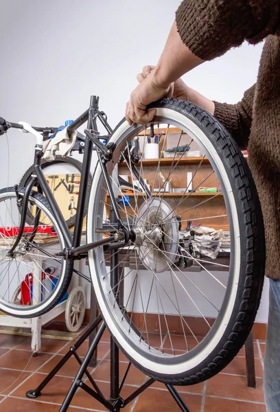 Real bicycle mechanic repairing custom fixie bike — Stock Photo, Image