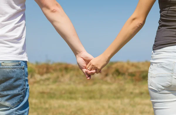 Zblízka lásky páru, drželi se za ruce venku — Stock fotografie