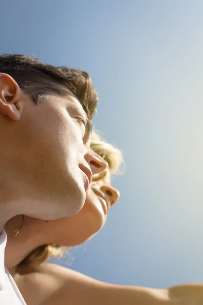 Vista inferior do casal de amor olhando um céu azul — Fotografia de Stock