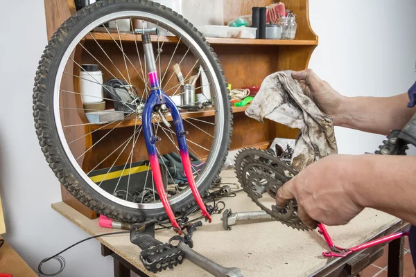 Hands of bicycle mechanic cleaning chainring bike — Stock Photo, Image