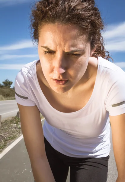 Tired runner girl sweating after running with sun Stock Picture