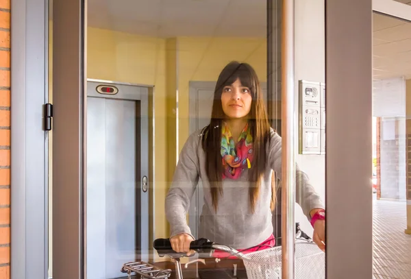 Dívka s fixie kolo otevření skleněné dveře ukončete — Stock fotografie