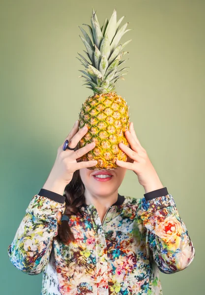 Chica de moda sosteniendo la piña en frente de la cara — Foto de Stock