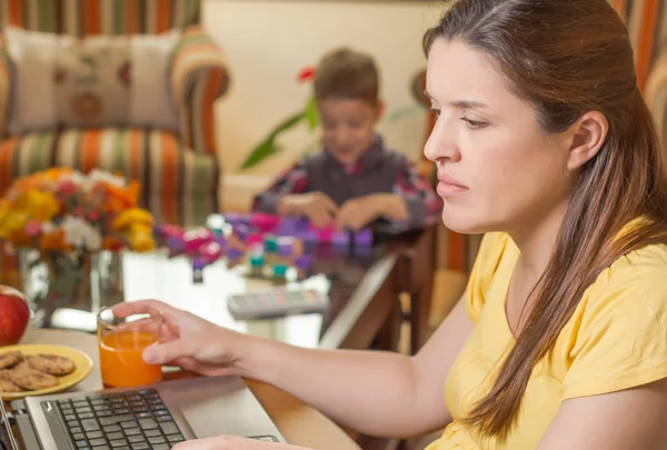 Mama însărcinată care lucrează în biroul de acasă cu fiul — Fotografie, imagine de stoc