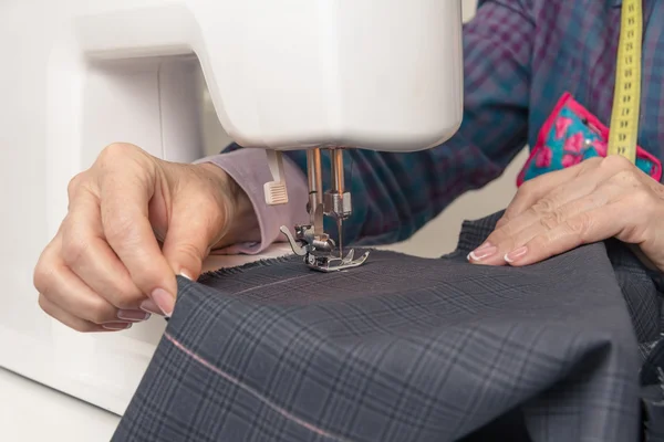 Manos de costurera trabajando en una máquina de coser — Foto de Stock