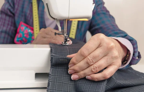 Mani da sarta che lavorano su una macchina da cucire — Foto Stock