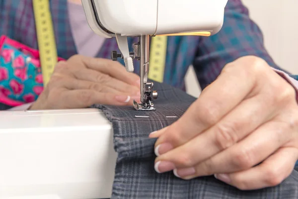 Manos de costurera trabajando en una máquina de coser — Foto de Stock