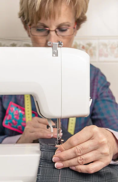 Senion naaister vrouw die werkt op naaimachine — Stockfoto