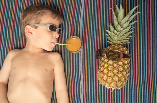 Lykkelig barn og ananas solbading over et håndkle – stockfoto