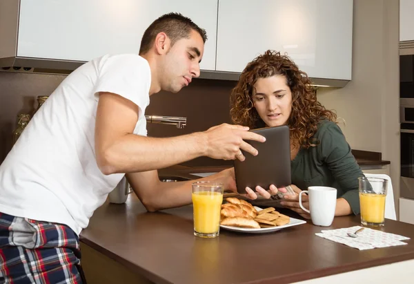 Casal feliz procurando tablet em casa café da manhã — Fotografia de Stock