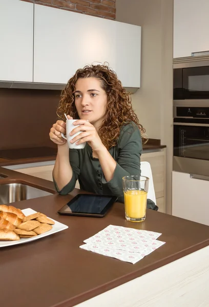 Tired young girl with cup of coffee in a breakfast — Stock Photo, Image