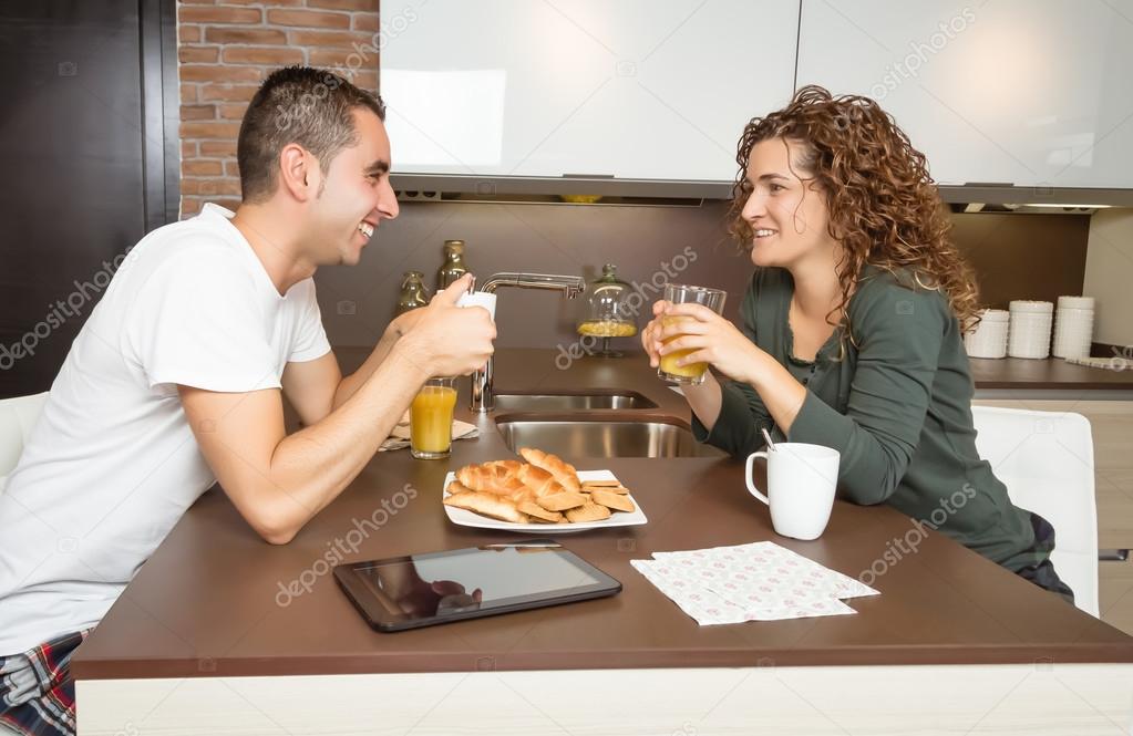 Happy love couple speaking at breakfast home