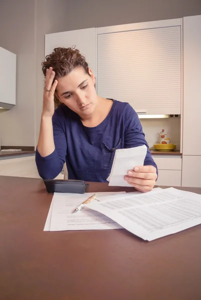 Mujer desempleada y divorciada con deudas revisando sus facturas mensuales — Foto de Stock