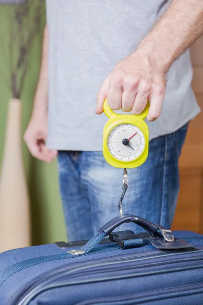 Man checking luggage weight with steelyard balance — Stock Photo, Image