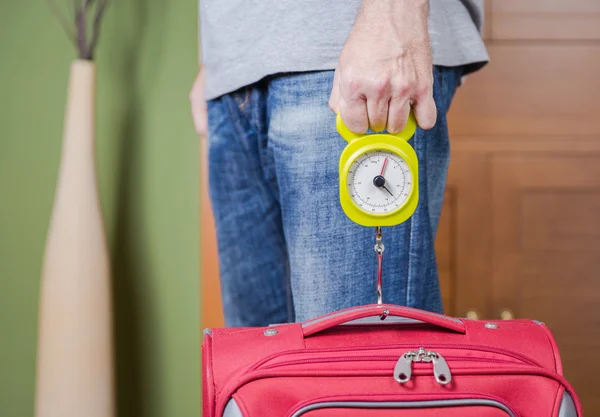 Man checking luggage weight with steelyard balance — Stock Photo, Image